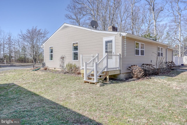 rear view of property with a lawn and a chimney