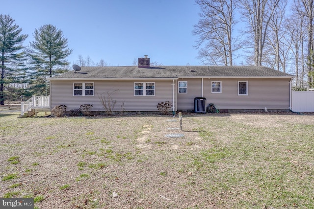 back of property featuring central air condition unit, a lawn, fence, and a chimney