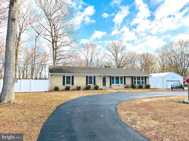 ranch-style house with brick siding, driveway, and fence