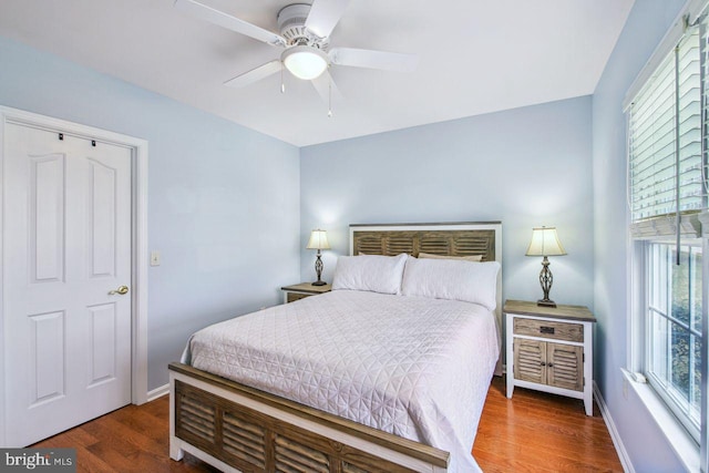 bedroom featuring wood finished floors, a ceiling fan, and baseboards