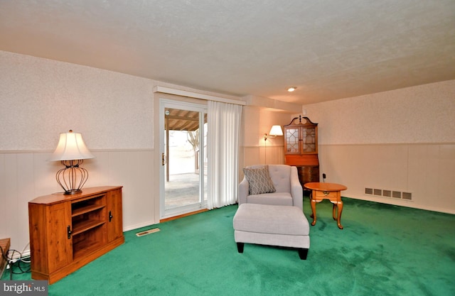 living area featuring a wainscoted wall, carpet, and visible vents