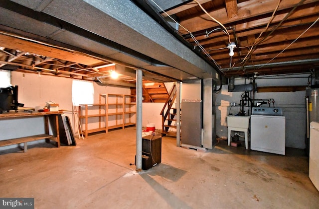 unfinished below grade area featuring stairway, a sink, washer / dryer, and heating unit