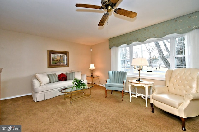 sitting room with carpet floors, a ceiling fan, and baseboards