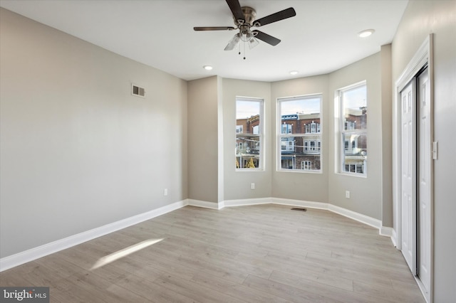 unfurnished bedroom with light wood-style flooring, visible vents, and baseboards