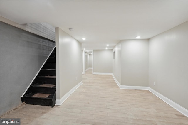 finished basement with stairs, baseboards, wood finished floors, and recessed lighting