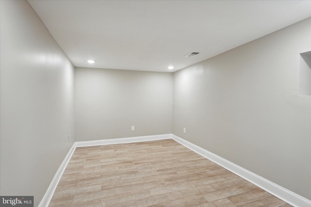 empty room featuring light wood finished floors, visible vents, and baseboards