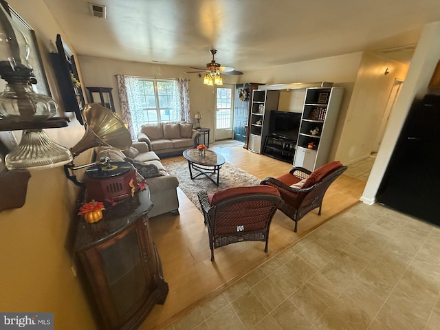 living area featuring a ceiling fan and visible vents