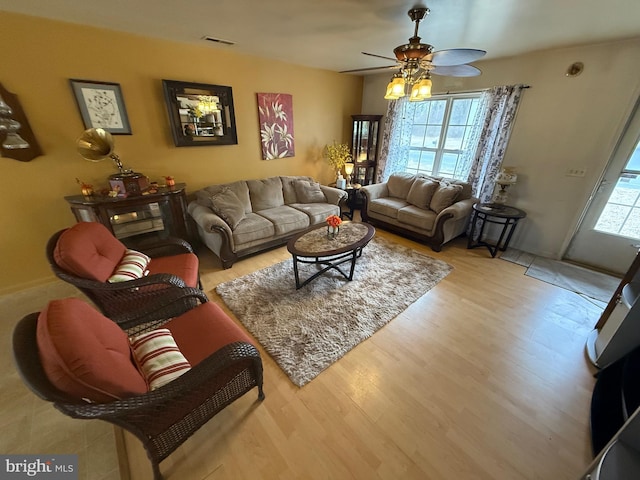 living area featuring ceiling fan, wood finished floors, and visible vents