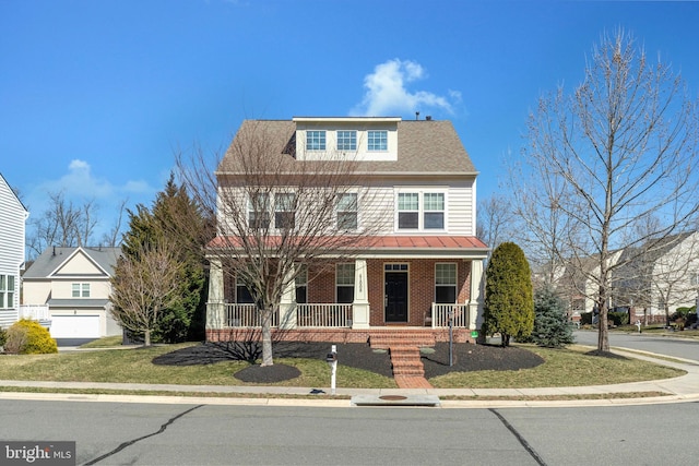 view of front facade with brick siding, covered porch, and a front yard