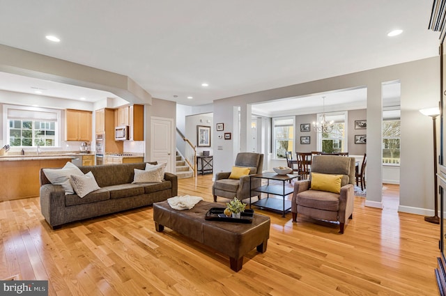 living room with recessed lighting, stairway, and light wood-style flooring