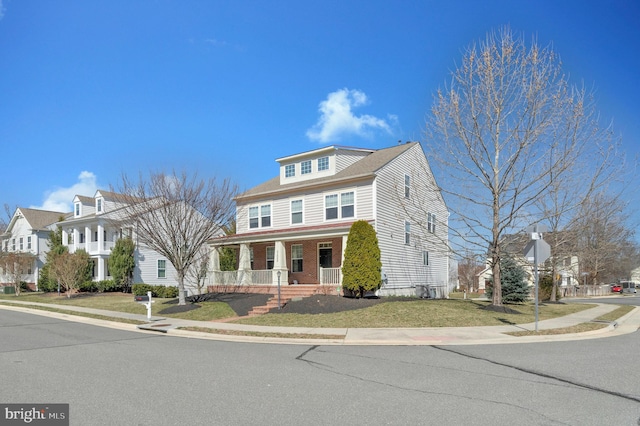 american foursquare style home with a front yard, covered porch, and a residential view