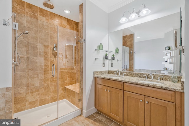 full bathroom with tile patterned flooring, ornamental molding, a shower stall, and a sink