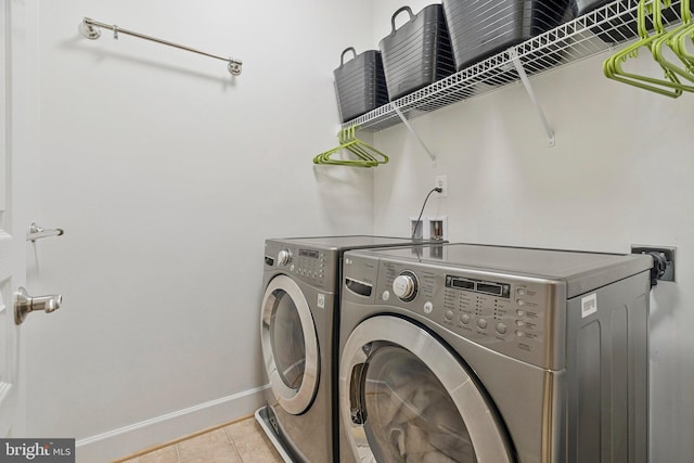 laundry room featuring washer and dryer, laundry area, light tile patterned floors, and baseboards