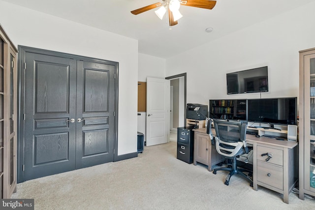 office space with light carpet, baseboards, and a ceiling fan