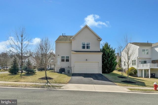 view of front of home featuring aphalt driveway, a garage, and a front lawn