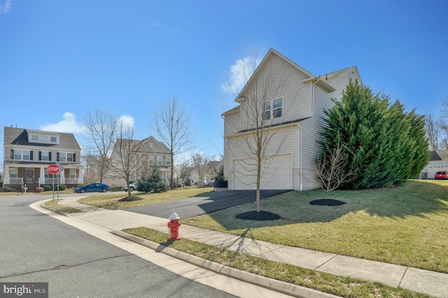 view of side of home with aphalt driveway, a lawn, and an attached garage