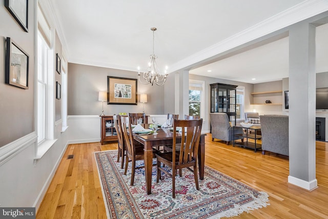 dining space featuring crown molding, baseboards, light wood-type flooring, and visible vents