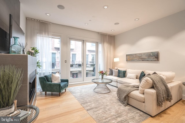 living area with light wood-style flooring, a fireplace, and recessed lighting