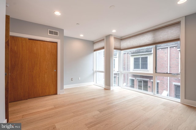 unfurnished living room featuring baseboards, visible vents, and light wood finished floors