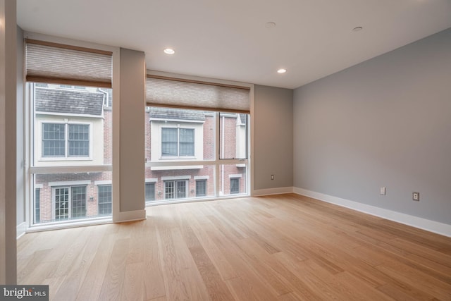 unfurnished living room with baseboards, recessed lighting, and light wood-style floors