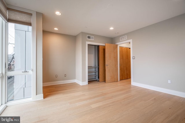 unfurnished bedroom with light wood-style floors, visible vents, and baseboards