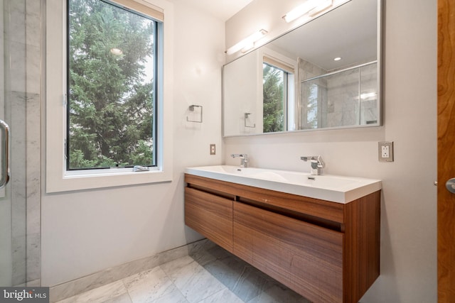 bathroom featuring a stall shower, marble finish floor, baseboards, and double vanity