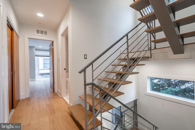 stairway featuring baseboards, visible vents, wood finished floors, and recessed lighting