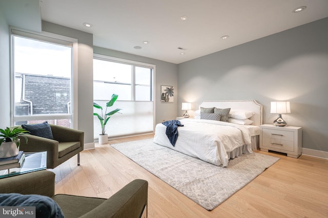 bedroom featuring light wood-style floors, recessed lighting, visible vents, and baseboards