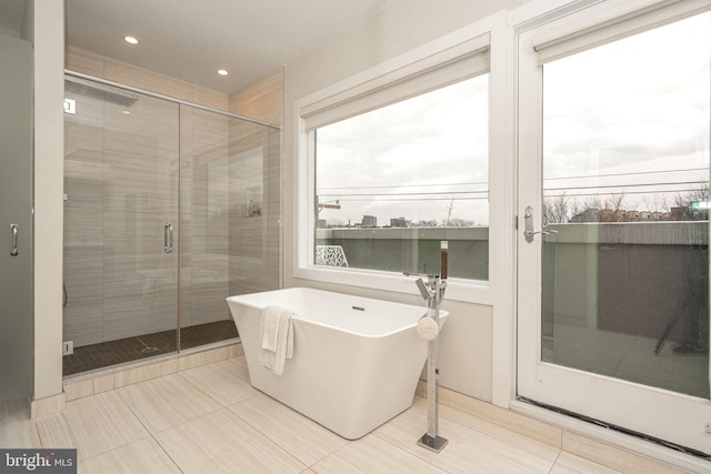 bathroom with a freestanding bath, a stall shower, and recessed lighting