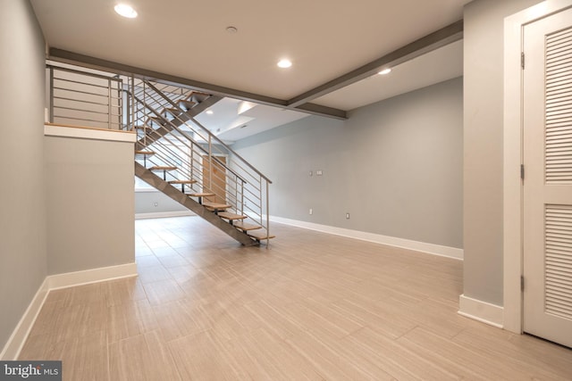 below grade area with stairway, baseboards, light wood-style floors, and recessed lighting