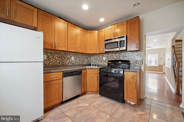 kitchen with stainless steel appliances, tasteful backsplash, dark countertops, and recessed lighting