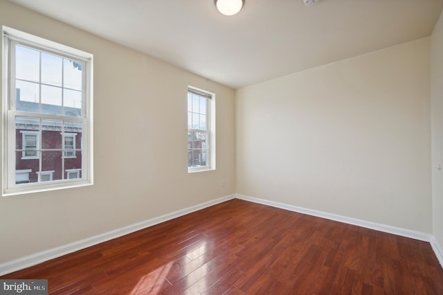 empty room featuring baseboards and wood finished floors