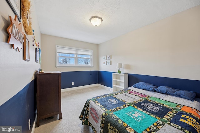 bedroom with a textured ceiling, carpet floors, and baseboards