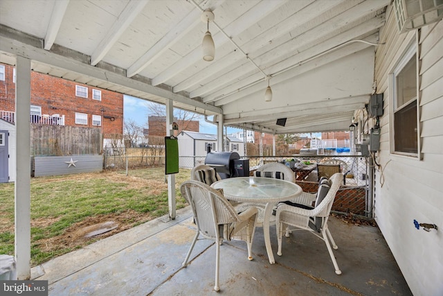 view of patio / terrace with an outbuilding, a storage unit, grilling area, outdoor dining space, and a fenced backyard