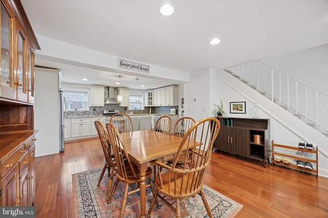 dining room with stairs, light wood finished floors, visible vents, and recessed lighting