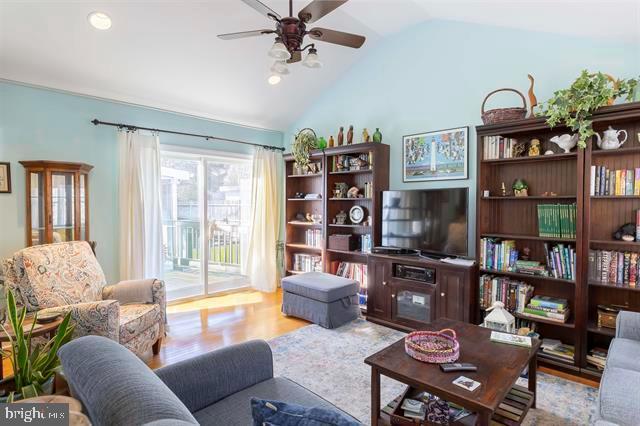 living room with vaulted ceiling, wood finished floors, and a ceiling fan