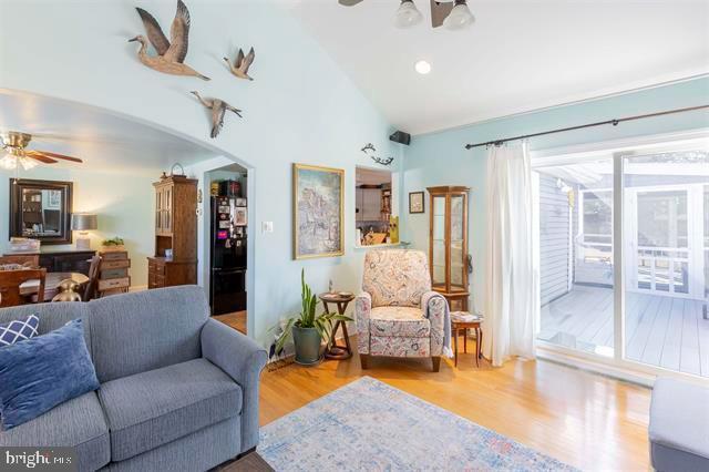 living room with high vaulted ceiling, arched walkways, a ceiling fan, and wood finished floors