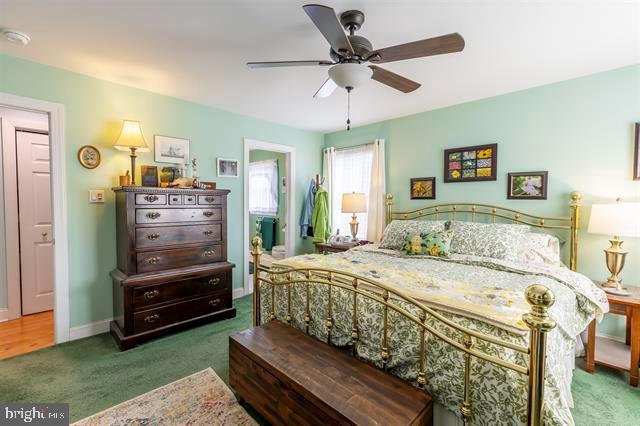 carpeted bedroom featuring a ceiling fan and baseboards