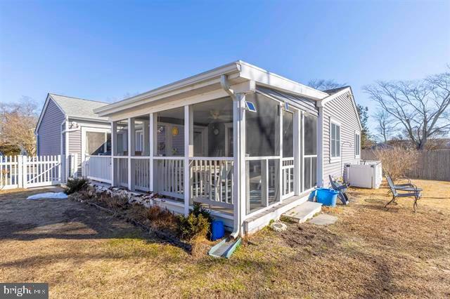 view of side of property featuring fence and a sunroom