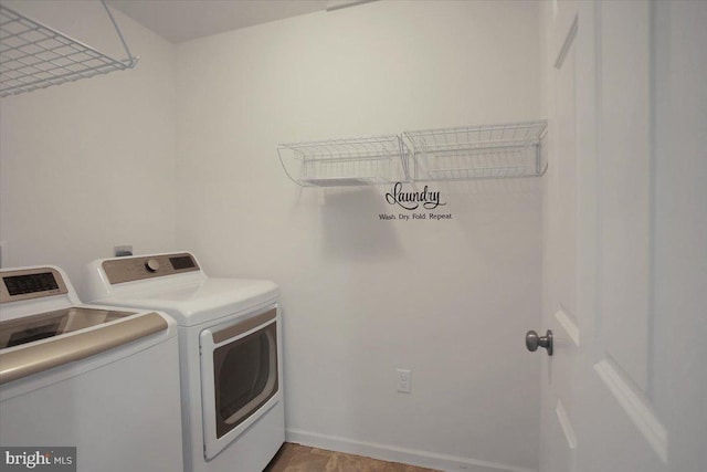 washroom with laundry area, baseboards, and washing machine and clothes dryer