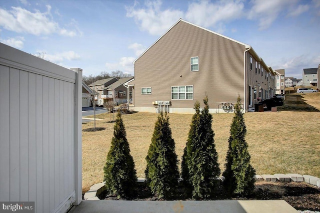 view of side of property with a lawn and a residential view