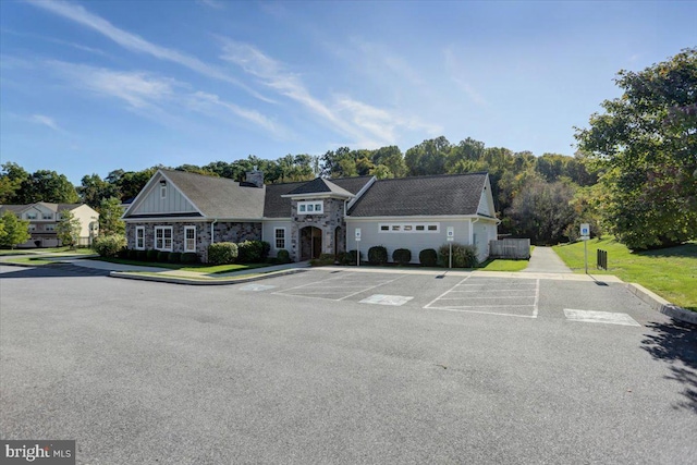 view of front of house featuring stone siding and uncovered parking