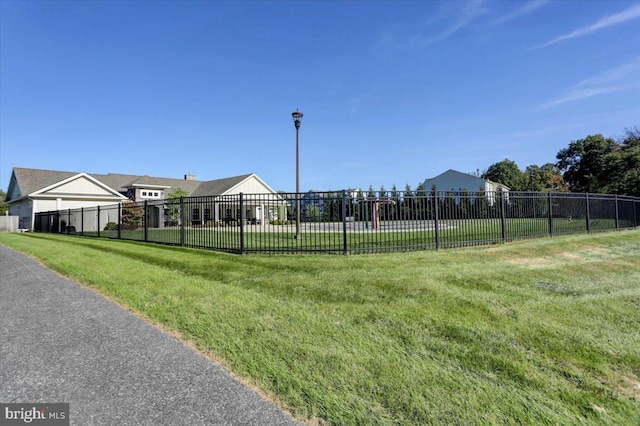 view of property's community with a yard and fence