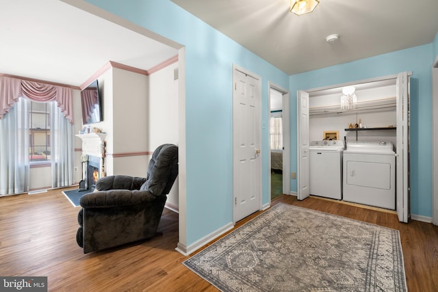 laundry area with laundry area, plenty of natural light, separate washer and dryer, and wood finished floors