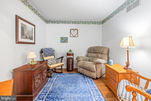 sitting room featuring visible vents and wood finished floors