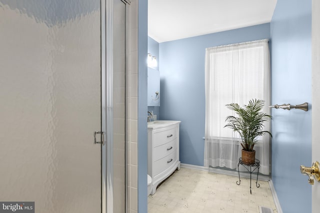 bathroom featuring a stall shower, vanity, a wealth of natural light, and tile patterned floors