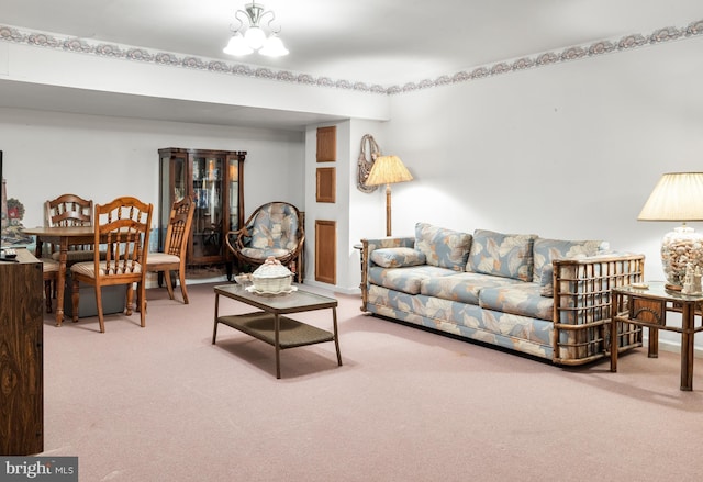 carpeted living room featuring a chandelier