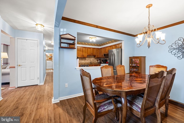 dining space featuring light wood-style flooring, baseboards, and crown molding