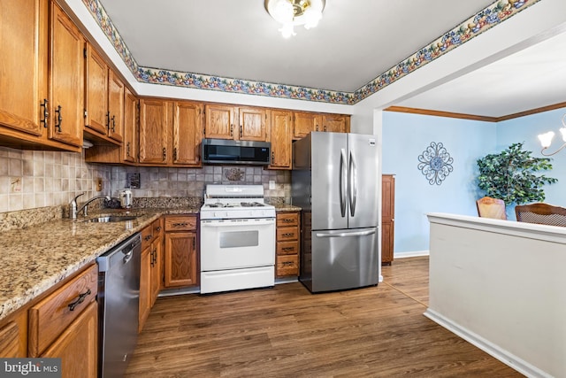 kitchen with brown cabinets, stainless steel appliances, and a sink