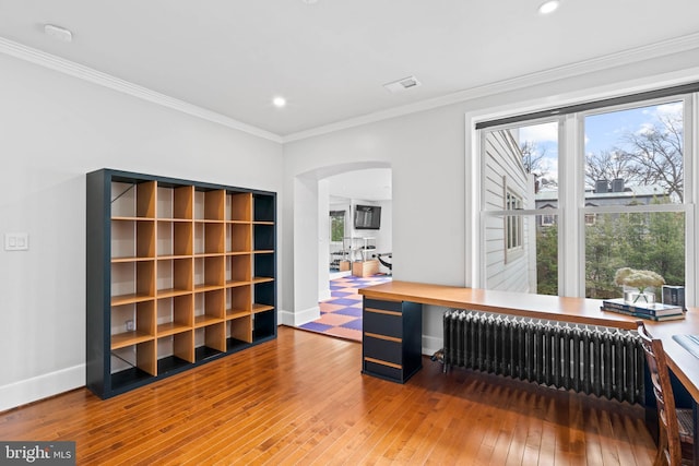 office with arched walkways, ornamental molding, wood-type flooring, and radiator